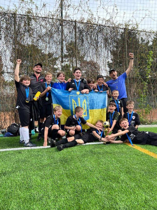 Team celebrating with Ukrainian flag and medals